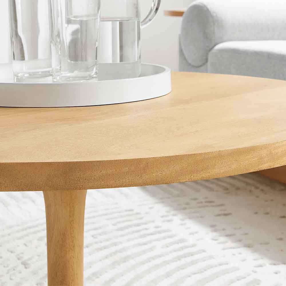 Table à café ronde Lina : charme rustique avec du bois de manguier massif. Finition en grain de bois riche. Solidité, durabilité et élégance dans un design moderne. Surface spacieuse pour l'organisation.