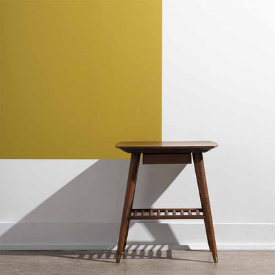 La table d'appoint Ari de Nuevo, inspirée du design Mid-century Modern, marie chaleur et simplicité. En peuplier américain, elle offre durabilité et élégance avec des accents en laiton.