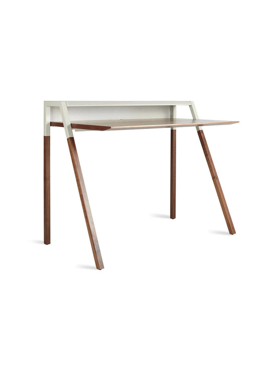 Découvrez le bureau Cant de Blu Dot, un meuble minimaliste en bois et acier pensé pour le télétravail. noyer