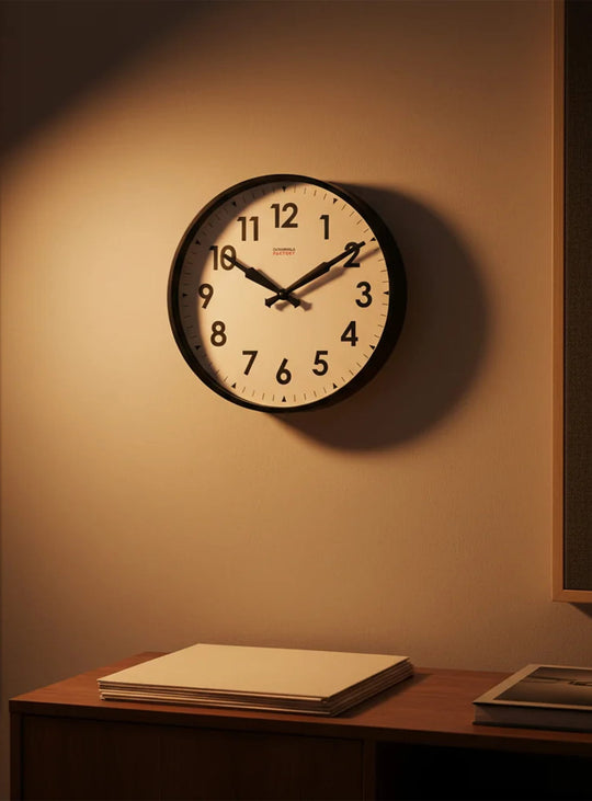 Horloge murale Cloudnola Factory : grands chiffres noirs, cadran beige et mouvement silencieux pour plus de confort.