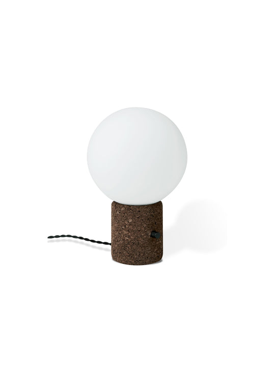 La lampe de table Monocle de Gus* Modern, une pièce captivante qui allie minimalisme et audace, avec un globe élégant et une base en liège.