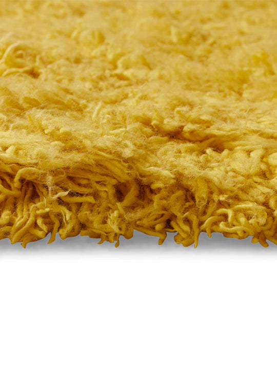 Tapis Fluffy jaune HKliving : un tapis design en laine aux nuances chaleureuses.