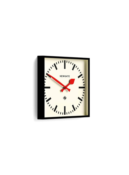 Newgate Number Five : horloge murale carrée, repères noirs, aiguilles rouges et design contemporain.