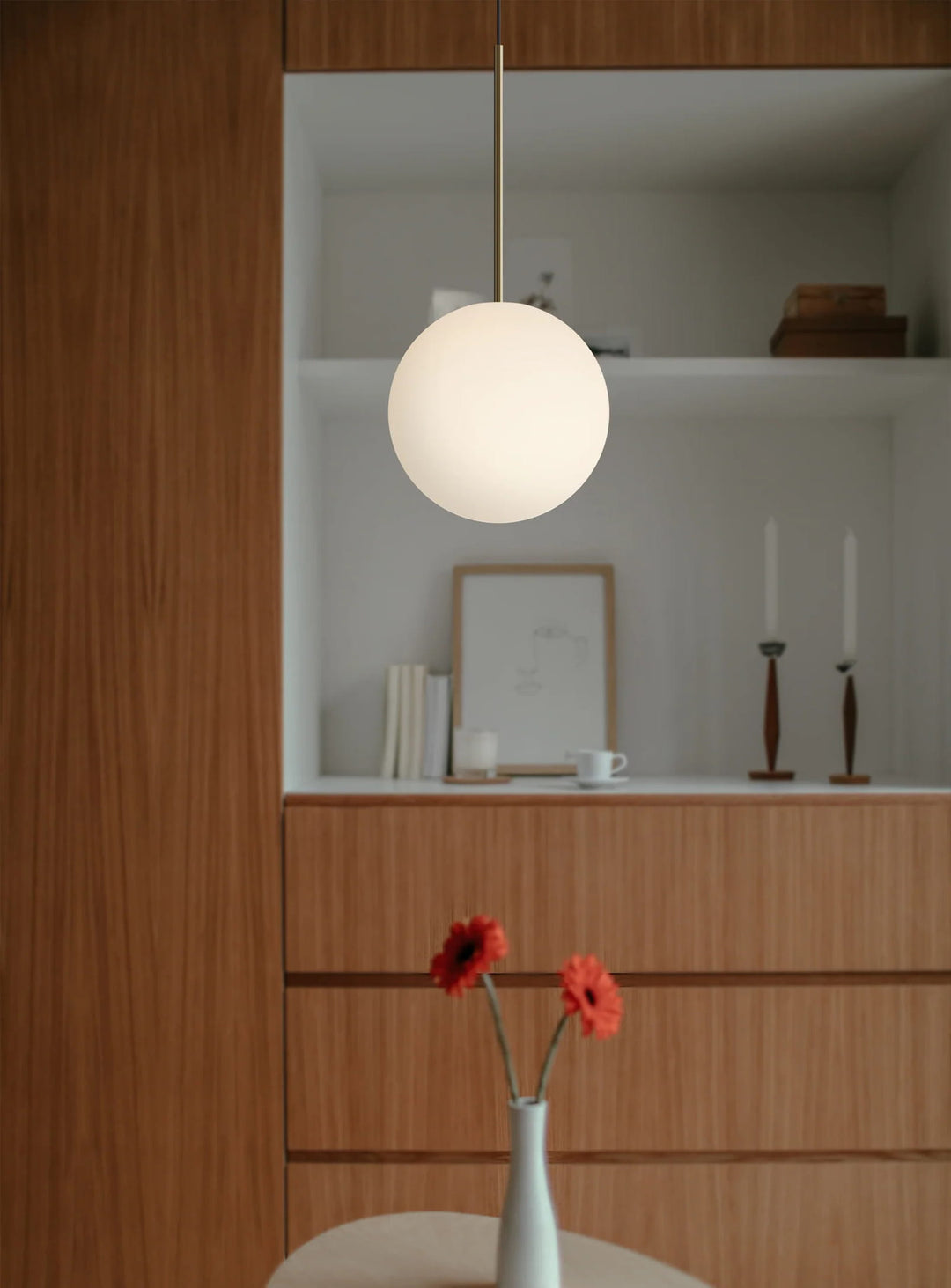 La lampe suspendue Bola Sphere de Pablo Designs sublime vos pièces avec son globe opalin et son design aérien. laiton