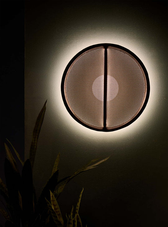 L'applique murale Pantaya de Pablo Designs crée un halo lumineux enveloppant grâce à sa maille sans couture. rouille