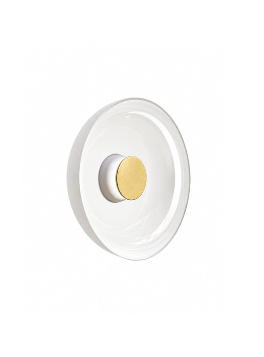L'applique murale Totem de Pablo Designs diffuse une lumière douce grâce à son élégant verre blanc opalin. blanc laiton