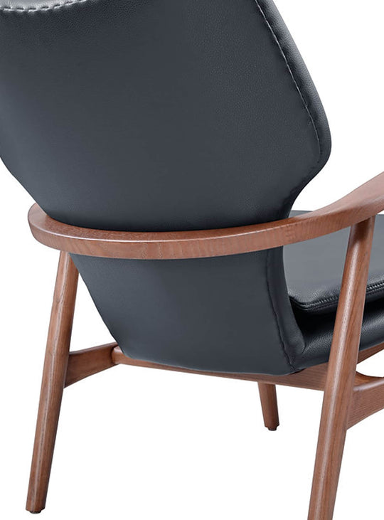Fauteuil Peggy Classique du design, un fauteuil en bois teinté noyer à l’allure chaleureuse et contemporaine. cuir noir