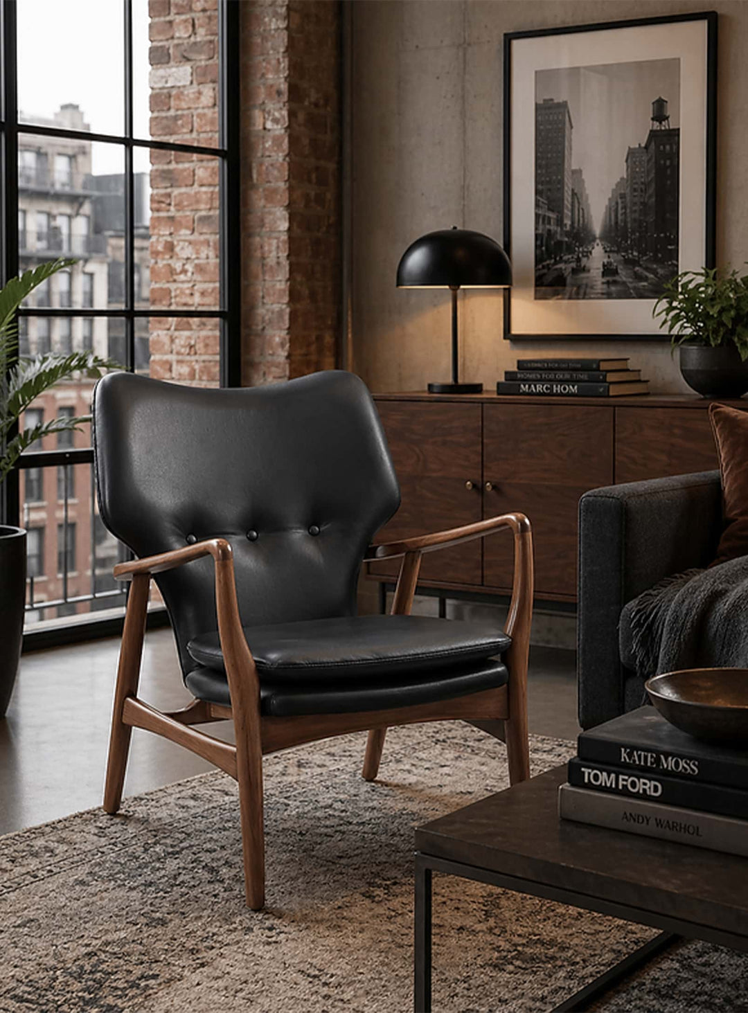 Fauteuil Peggy Classique du design, une assise élégante en bois teinté noyer au confort généreux. cuir noir
