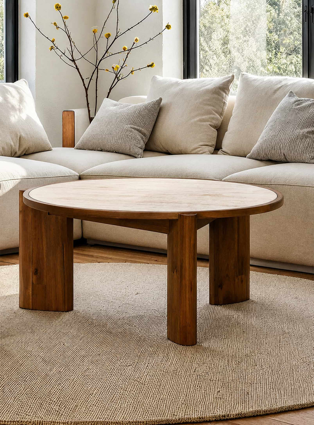 Table à café ronde Remix avec plateau effet travertin et pieds en bois massif d'acacia au design chaleureux.