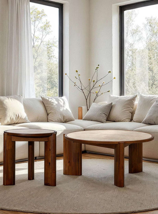 Table à café ronde Remix avec plateau beige effet pierre naturelle et pieds robustes en bois d'acacia.