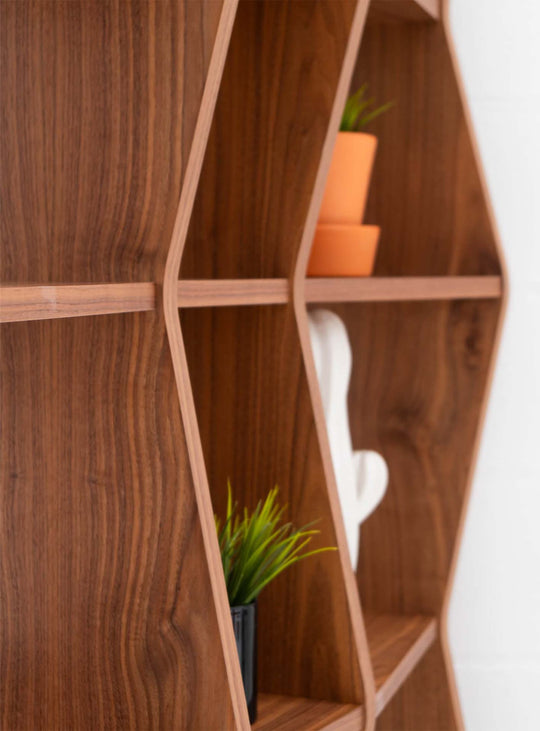 La bibliothèque Wave de TemaHome transforme le rangement en élément décoratif grâce à son design ouvert et graphique. noyer