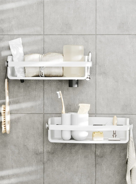 Panier de douche Flex d'Umbra avec crochets et drainage intégré pour ranger shampoings, gels douche et accessoires. blanc