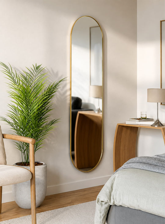 Miroir Hubba Pill d'Umbra, à la silhouette allongée et au cadre métallique élégant en laiton ou titane.