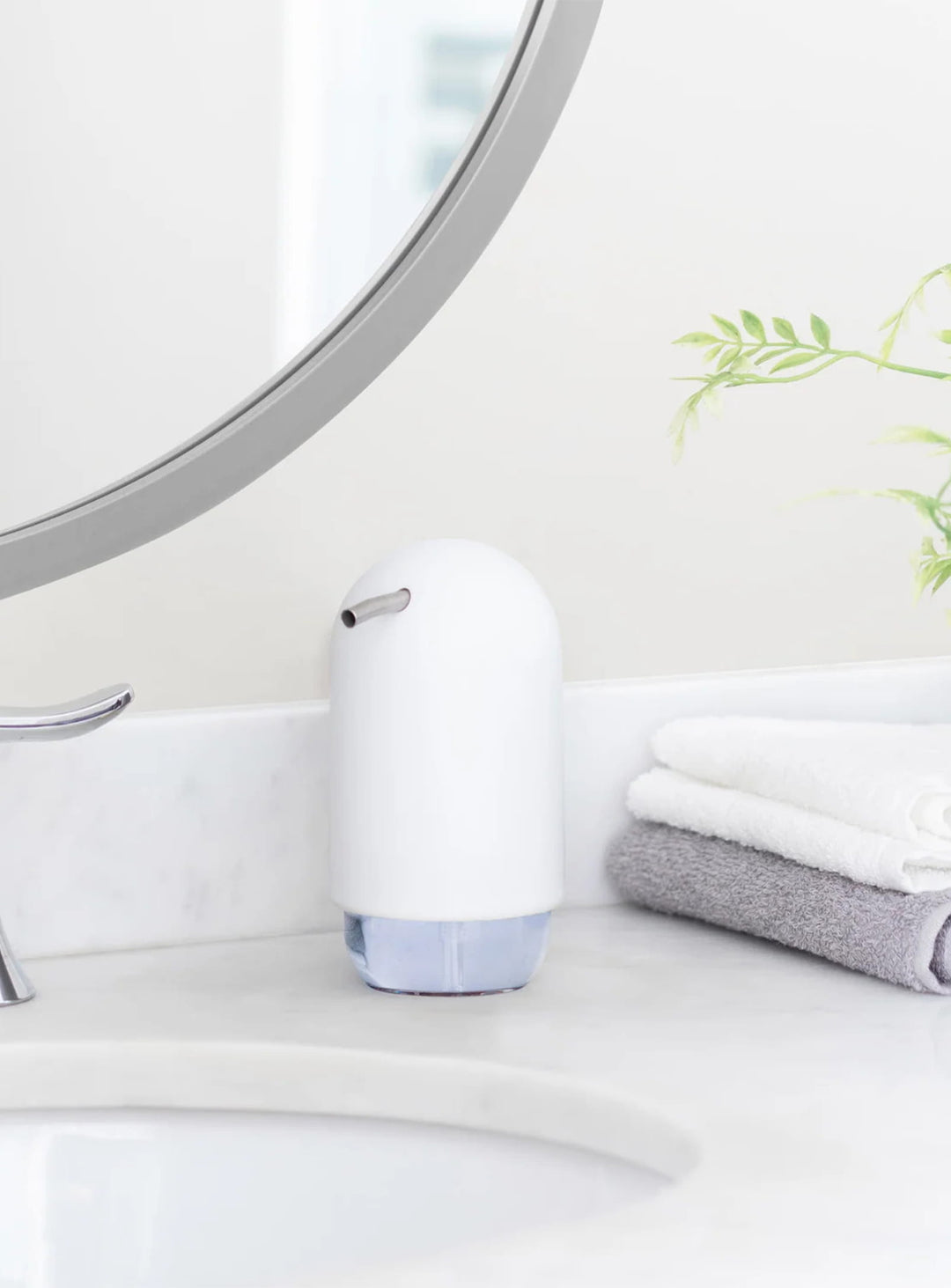 Distributeur de savon Touch Umbra, un accessoire compact au design arrondi et à la finition mate douce au toucher.