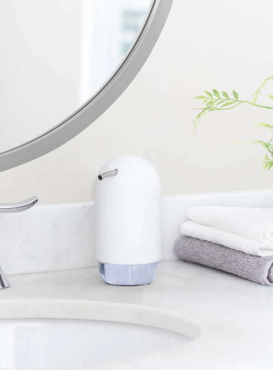 Distributeur de savon Touch Umbra, un accessoire compact au design arrondi et à la finition mate douce au toucher.