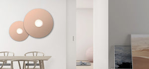 La lampe murale ou à fixer au plafond Bola Disc de Pablo Deisgns associe un élégant globe en verre opalin à des disques en acier inoxydable ou en aluminium chromés, laiton, or rose et laqué blanc pour apaiser les goûts les plus exigeants.