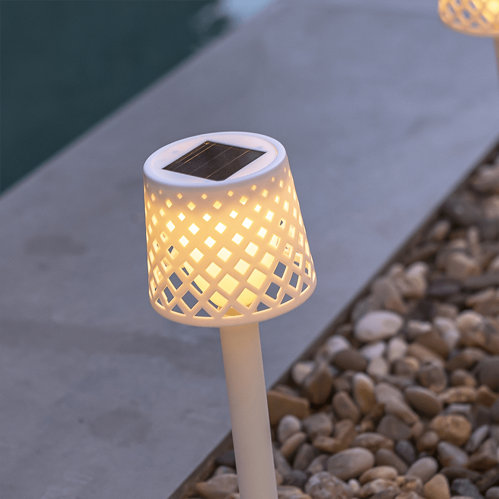 Lampe solaire Gretita de Newgarden : un bijou écologique pour votre jardin. Rechargeable au soleil grâce à son panneau solaire intégré, cette lampe en plastique recyclé illumine vos extérieurs avec éclat