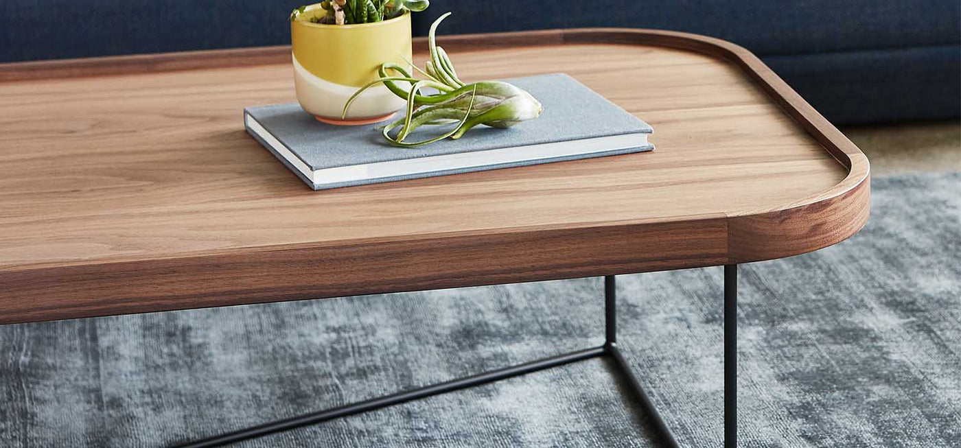 La table à café rectangulaire Porter offre une vaste surface à profil bas avec des éléments raffinés et modernes. Elle présente un plateau en bois plaqué et un bord surélevé en bois massif avec des coins arrondis.