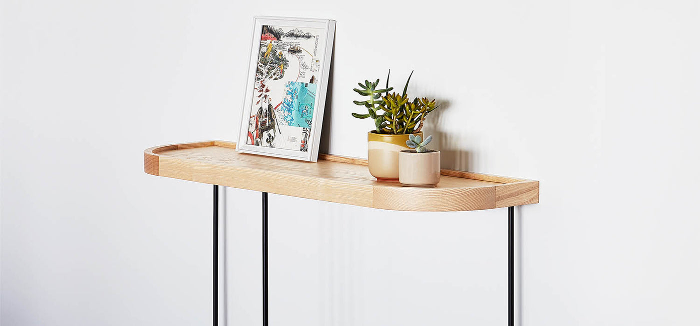 La table console Porter de Gus* Modern est une pièce d'accent minimaliste et géométrique qui convient parfaitement aux espaces modernes. Elle présente un plateau en bois plaqué et un bord en bois massif surélevé aux coins arrondis