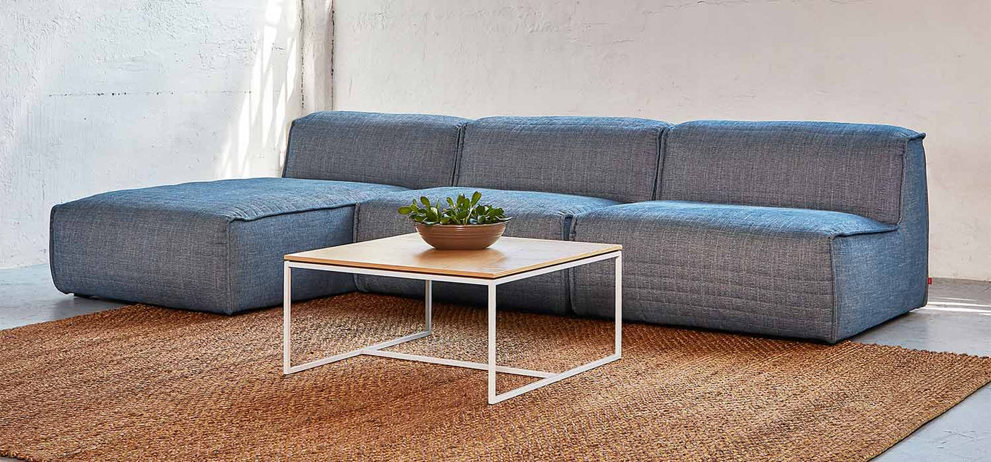 La table à café carrée Tobias de Gus* Modern est une pièce d'accent minimaliste et géométrique qui convient parfaitement aux espaces modernes. Le plateau carré présente un arrangement dynamique de panneaux en grain de bois de noyer