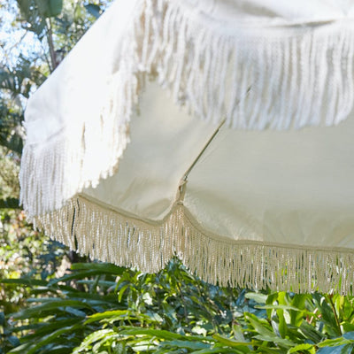 Nüspace Mobilier (Canada) présente le parasol d'extérieur Jardin Umbrella par Basil Bangs, avec ses franges luxueuses.
