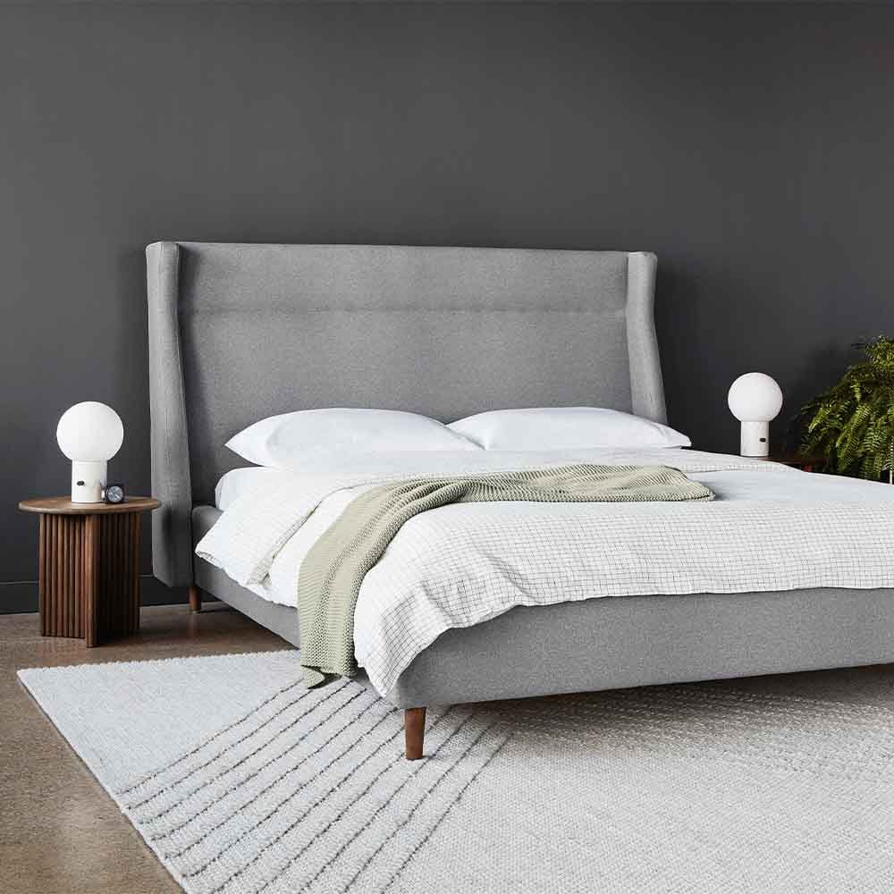 Le lit Carmichael de Gus* Modern fusionne les sensibilités traditionnelles et contemporaines. Le design comprend une tête de lit, un pied de lit et des barrières latérales entièrement rembourrés, avec d'élégants pieds effilés en bois massif.