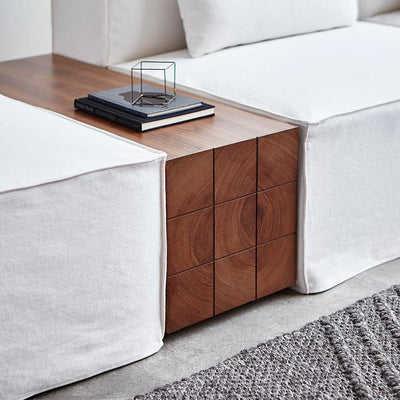 Voici la touche brut et boisée indispensable au nouveau look de votre sofa Mix Modular de Gus* Modern. Une table massive et déconcertante de simplicité, un bloc de noyer à la touche graphique qui s'intègre parfaitement entre deux modules