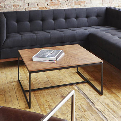 La table à café carrée Tobias de Gus* Modern est une pièce d'accent minimaliste et géométrique qui convient parfaitement aux espaces modernes. Le plateau carré présente un arrangement dynamique de panneaux en grain de bois de noyer