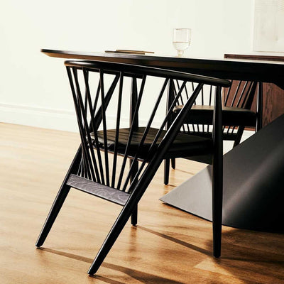 La chaise Danson de Nuevo : élégance et simplicité incarnées. Son dossier ventilé et sa construction en bois massif offrent une sophistication raffinée à votre espace.