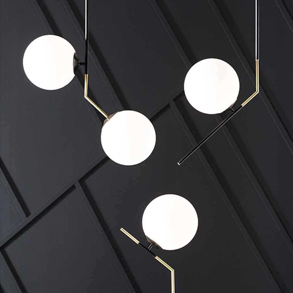 La lampe Declan, héritière de l'Art déco, associe acier noir mat et laiton. Globes en verre blanc givré diffusant une lumière douce, elle apporte une touche artistique et élégante à votre intérieur.