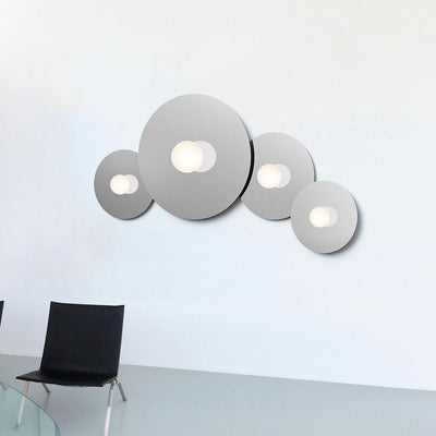 Bola Disc Flush de Pablo Designs est un système de lampe murale à LED unique et expressif, à fixer au plafond ou au mur, avec pour objectif de fournir à la fois de la lumière directe et de la lumière réfléchie.