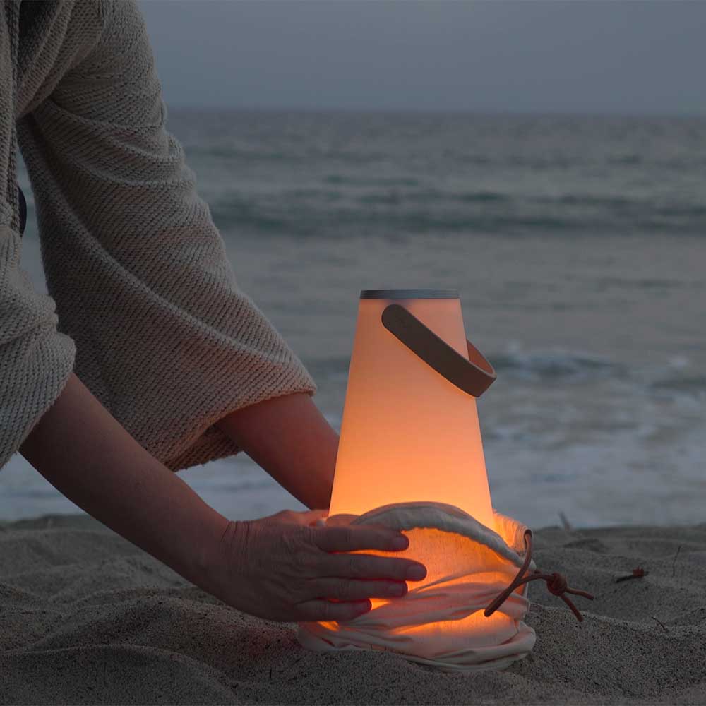La lampe de table UMA par Pablo Designs redéfinit la lanterne portable pour l'ère moderne. Fusionnant la technologie LED Warm Dim à la pointe de la technologie avec un son surround haute fidélité à 360°