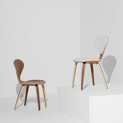 Idéale pour les petits espaces, la chaise à dîner Cherner présente une structure en bois, contrastant avec une assise et un dossier en cuir.