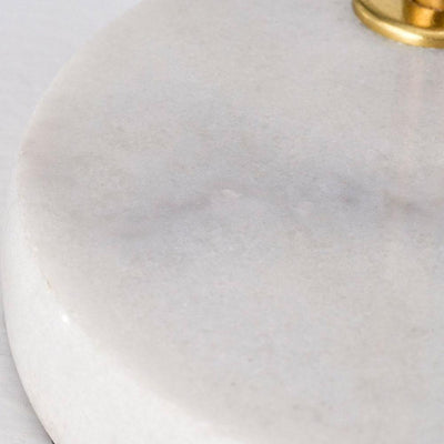 La lampe de table Oda est une lampe d'appoint d'exception avec sa tige dorée et sa base en marbre.