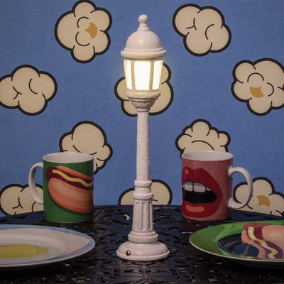 La lampe de table en forme de lampadaire par Seletti a comme un arrière-goût de rétro. Une version plus compacte que celui que vous pouviez trouver dans les rues. Ce mini lampadaire se fera un plaisir d'illuminer vos dîners les plus excentriques !