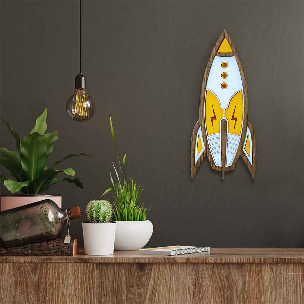 Accrochez cette fusée décorative en bois d'Umasqu sur le mur de votre salon ou de la chambre de vos enfants, vous ne pouvez pas vous tromper avec cette œuvre. Prêt pour des voyages intergalactiques ?