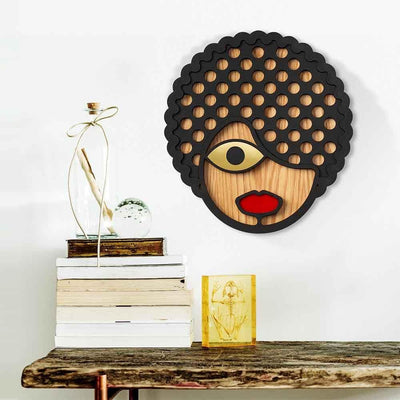 Le masque décoratif Roxy en bois coloré, fabriqué à la main par Umasqu, s'inspire de la culture africaine et de ses signes distinctifs uniques comme la coupe de cheveux.